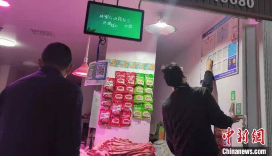 图为郑州一家农贸市场内,市场监管人员在对销售羊肉的商户逐一检查。 赵晖 摄 图为郑州一家农贸市场内,市场监管人员在对销售羊肉的商户逐一检查。 赵晖 摄
