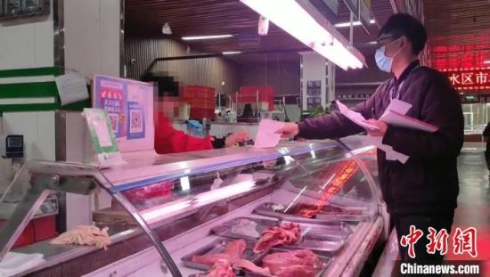 图为郑州一家农贸市场内,市场监管人员在对肉品经营商户逐一检查。 赵晖 摄 图为郑州一家农贸市场内,市场监管人员在对肉品经营商户逐一检查。 赵晖 摄